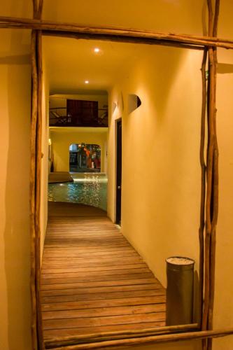 a wooden walkway leading to a pool in a house at Kinbe Hotel Boutique in Playa del Carmen