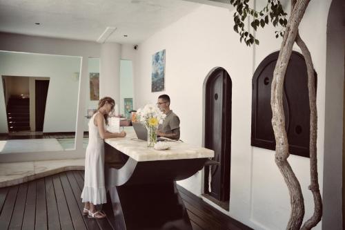 a woman and a man sitting at a table in a room at Hotel Kinbe in Playa del Carmen