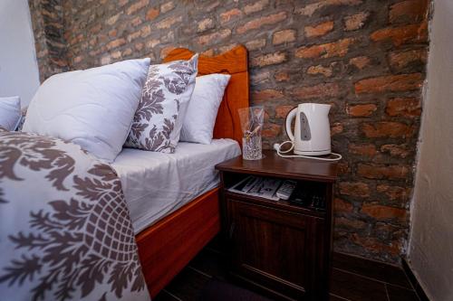 a bedroom with a bed and a brick wall at Salaš Isailovi in Sremska Mitrovica