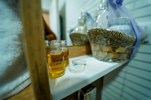 a shelf with two bottles of oil and glasses on it at Salaš Isailovi in Sremska Mitrovica
