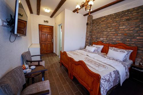 a bedroom with a large bed and a brick wall at Salaš Isailovi in Sremska Mitrovica