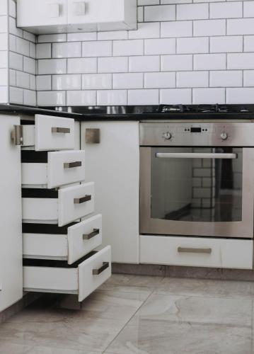 a kitchen with white cabinets and an oven at The Living Collective Villa in Hilton