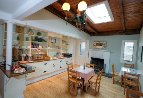 a kitchen and dining room with a table and a fireplace at Pequot Hotel in Oak Bluffs