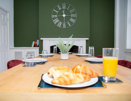 a table with croissants and a plate of orange juice at Porchester House Nottingham in Nottingham
