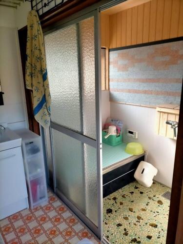 a bathroom with a sliding glass door with a toy refrigerator at Neko Neko La Campagne in Tamba