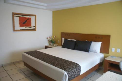 a bedroom with a large bed in a room at Hotel Arcos Aeropuerto in Veracruz