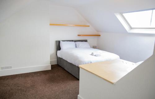 a small bedroom with a bed and a table at Porchester House Nottingham in Nottingham