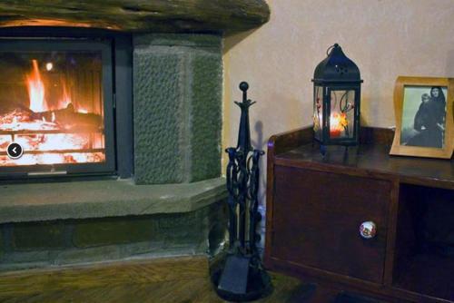 a living room with a fireplace and a lamp at Oikies Katogi in Pramanta