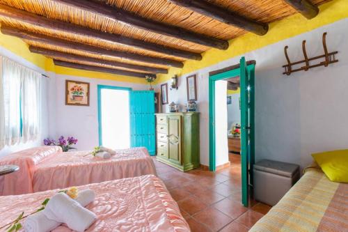 a bedroom with two beds and a room with a bathroom at Casa Rosa, con encanto y piscina climatizada in Frigiliana