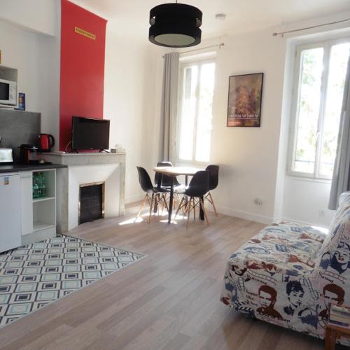 - un salon avec une cheminée, une table et des chaises dans l'établissement Villa Zola, à Aix-en-Provence