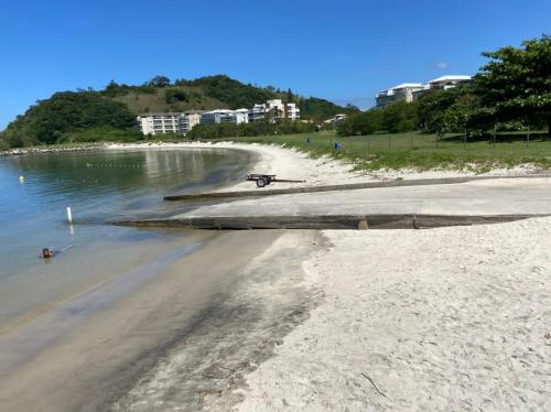 a bike on a beach next to the water at Loft Reserva do Sahy - Mangaratiba in Mangaratiba