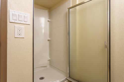 a shower with a glass door in a bathroom at Riverfront Inn Roseburg in Roseburg