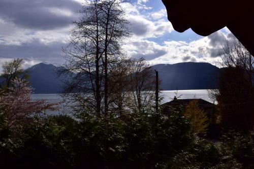a view of a lake with mountains in the background at The Rockwell-Harrison Guest Lodge in Harrison Hot Springs