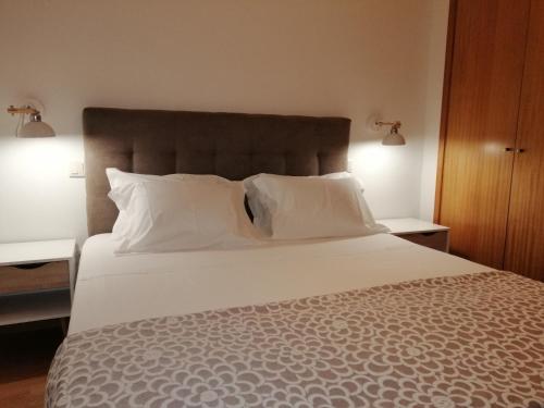 1 dormitorio con 1 cama grande con almohadas blancas en Casa de Ribes T1 Linda Vista en Geres