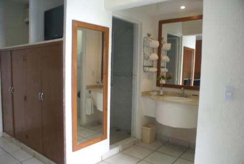a bathroom with a shower and a sink and a tub at Hotel Arcos Aeropuerto in Veracruz