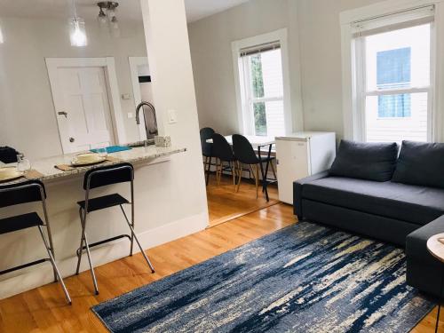 a living room with a couch and a kitchen at Renovated, 10 Min from the city in Boston
