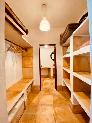 a walk in closet with white shelves and a mirror at Casa Dos Patos in Flecheiras