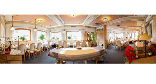 a dining room with tables and chairs and windows at Hotel Pfrontener Hof in Pfronten