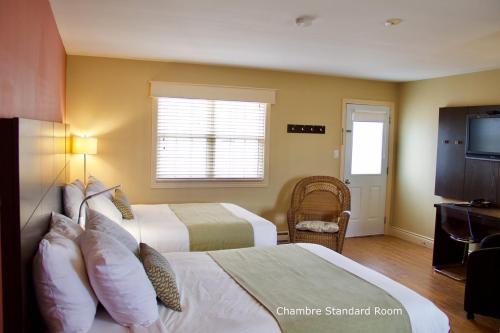 a hotel room with two beds and a television at Parlee Beach Motel in Shediac