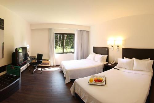 Habitación de hotel con 2 camas y TV en Fiesta Inn Xalapa, en Xalapa