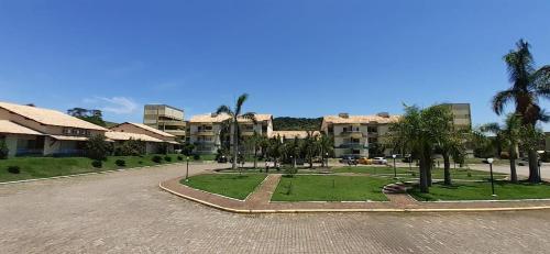 un parking vide avec des palmiers et des bâtiments dans l'établissement Village Aldeia das Águas, à Ipiabas