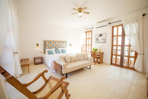 a bedroom with a bed and a couch and a fan at Bioma Boutique Hotel in Mompos