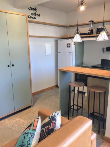 a living room with a couch and a kitchen with a counter at Hospedaria da Lagoa in Florianópolis