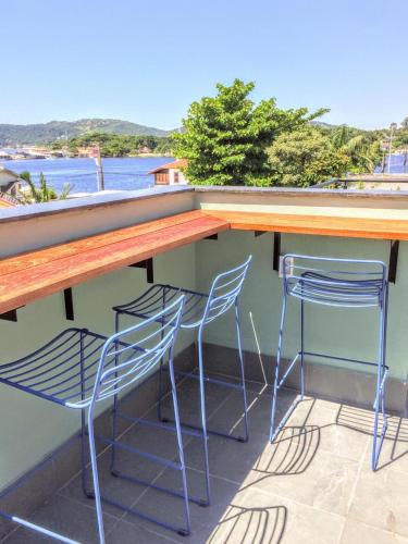 two chairs and a bar with a view of the water at Hospedaria da Lagoa in Florianópolis