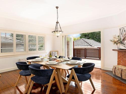 a dining room with a wooden table and chairs at Kookaburra Cottage in Bowral