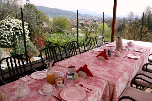 une table rose installée sur un balcon avec vue dans l'établissement Dimora del Riccio, à Bergame