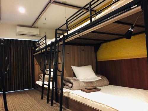 a room with two bunk beds in a room at The Base Sakai Higashi Apartment Hotel in Sakai