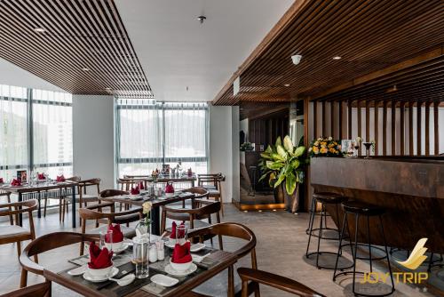 un restaurante con mesas y sillas y un bar en Joy Trip Hotel & Spa Nha Trang, en Nha Trang