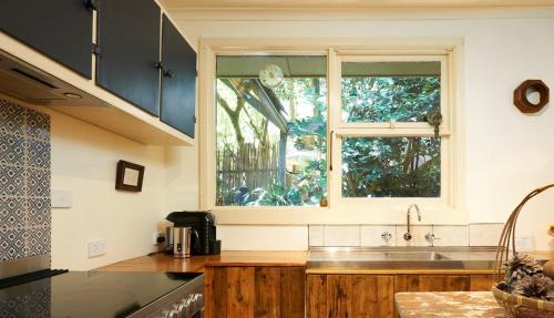 a kitchen with a sink and a window at Koko Guesthouse - One Bedroom Option in Olinda