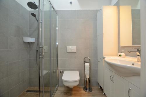 ein Bad mit einer Dusche, einem WC und einem Waschbecken in der Unterkunft Apartment Happy sound in Rijeka