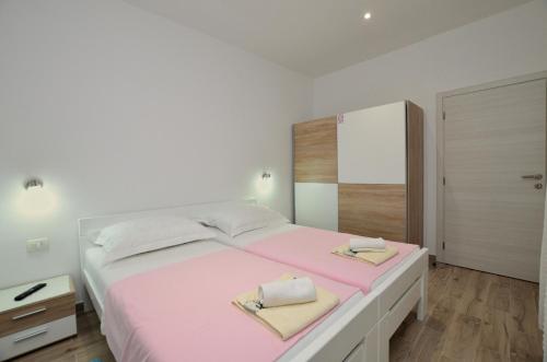 a bedroom with a large bed with two towels on it at Apartment Happy sound in Rijeka