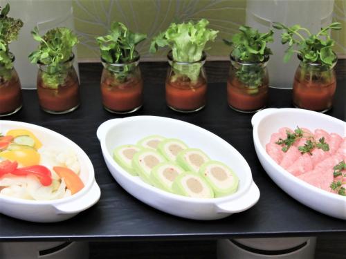 a table topped with bowls of food and vegetables at QuintessaHotel FukuokaTenjin Comic&Books in Fukuoka