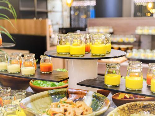 un buffet de comida con vasos de zumo de naranja en Quintessa Hotel Fukuoka Tenjin Minami, en Fukuoka