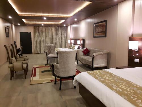 a hotel room with two beds and a table and chairs at Maple Leaf Hotel in Kharar