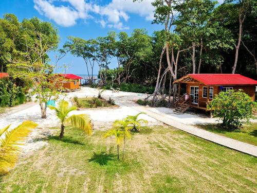 a small house with a red roof on a beach at Seaside Chateau Resort in Belize City