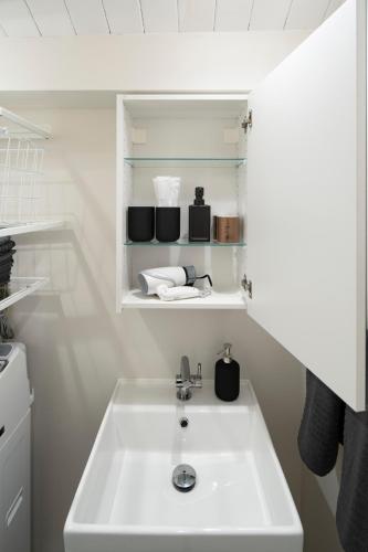 a bathroom with a white sink in a room at Japan Sessions KANZAKI 02 in Osaka
