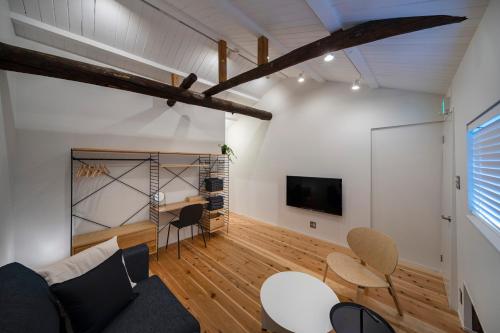 a living room with a couch and a table and chairs at Japan Sessions KANZAKI 02 in Osaka
