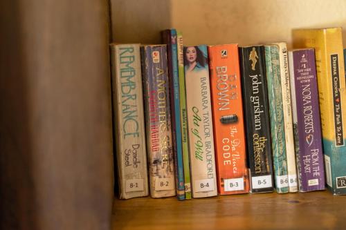 a row of books sitting on a shelf at The Plains Green in Ambawela