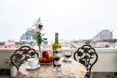 uma mesa com uma garrafa de vinho e dois copos em Rose Hotel Quảng Bình em Dong Hoi