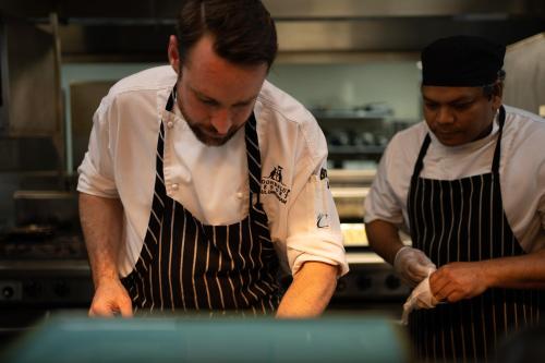 two chefs standing in a kitchen preparing food at Joondalup Resort in Perth