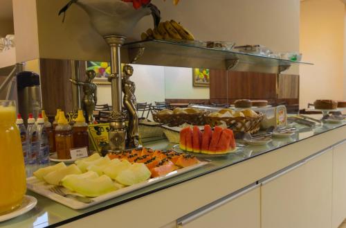 uma linha de buffet com diferentes tipos de alimentos em exposição em Hotel Cidade Araxá em Araxá