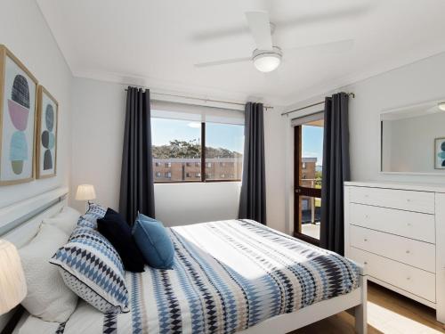 a bedroom with a bed and a window at Promenade, 12 8 Intrepid Cl - fantastic waterfront unit with air con and WiFi in Nelson Bay