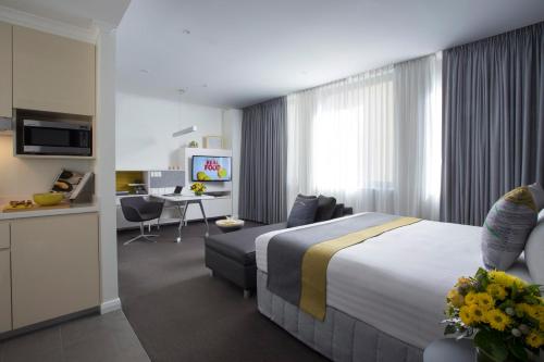 a hotel room with two beds and a table at Citadines St Georges Terrace in Perth
