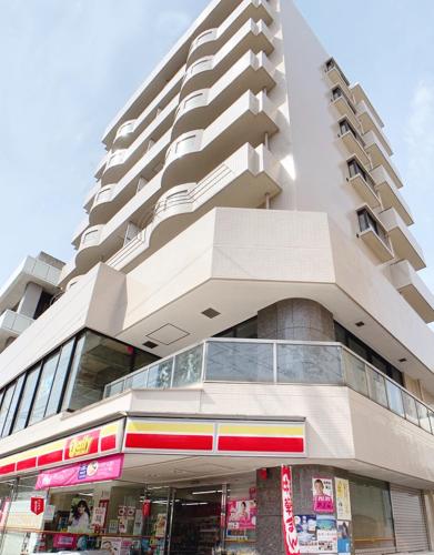 a tall building with a store in front of it at OUCHI HOTEL Hijiyama in Hiroshima