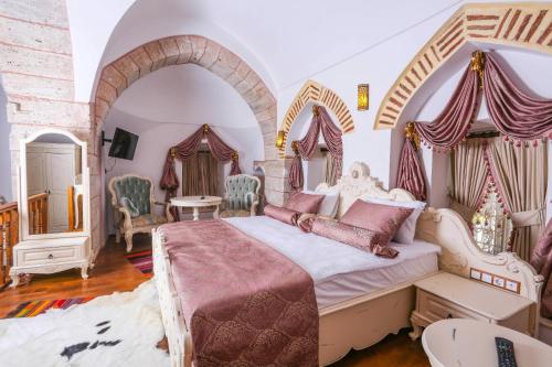a bedroom with a large bed and an archway at BEHRAMPAŞA OTEL &CAFE &RESTAURANT in Sivas