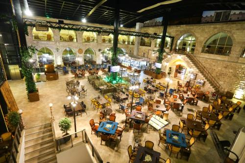 BEHRAMPAŞA OTEL &CAFE &RESTAURANT في شيفاش: اطلالة علوية على مطعم به طاولات وكراسي